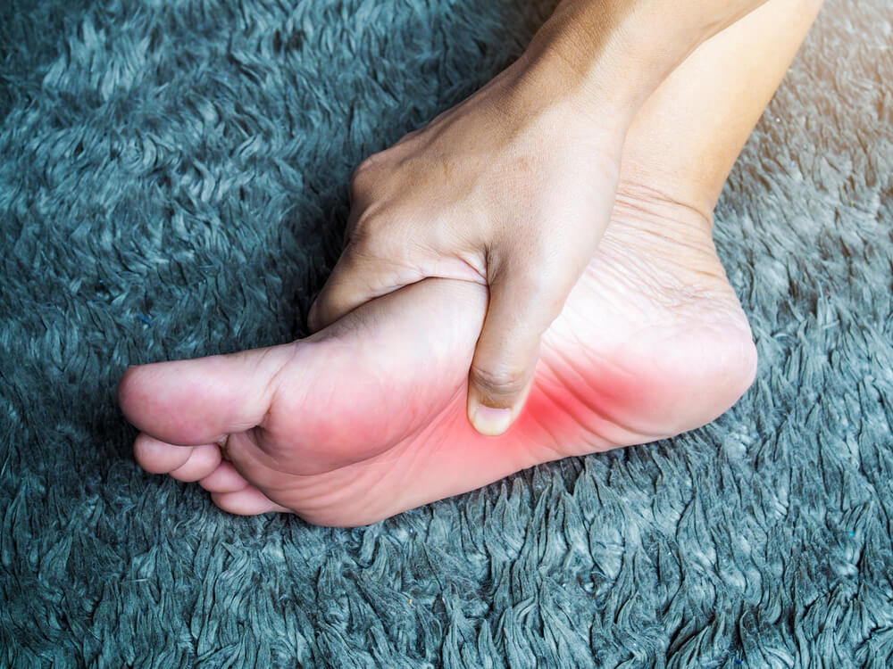 A foot glowing red and being held by a hand